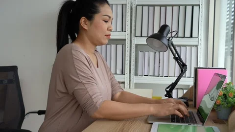 Asian woman using laptop for work at home Stock Footage 116378719