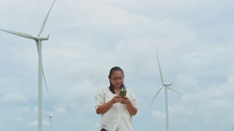 Asian woman using mobile phone outdoors with wind turbine background Stock-Footage 342906366