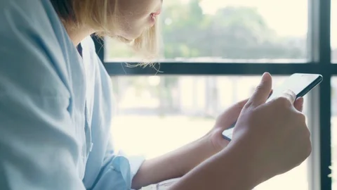 Asian woman using smartphone while sitting on table in cafe. Stock Footage 104372786