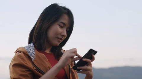 Asian  woman using smartphone while sitting on the  beach camp Stock Footage 124416559