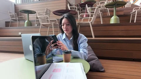 Asian Woman Using Smartphone While Working at Outdoor Cafe in Bangkok Stock Footage 344233138