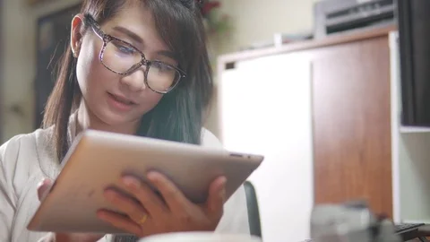 Asian woman using tablet computer touchscreen in cafe Stock Footage 75951817