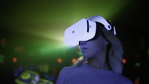 Asian woman in virtual reality headset dancing at party in neon light rays Stock Footage 237759341