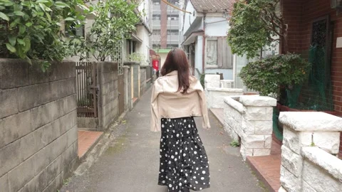 Asian woman walks through a tiny street. Back shot. No face. Stock Footage 224445153