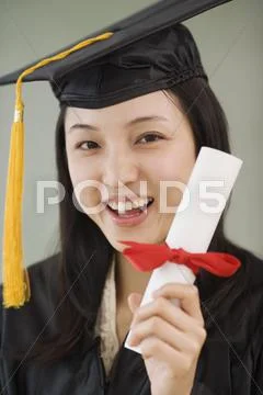 Asian woman wearing graduation cap and holding diploma Stock Photos