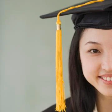Asian woman wearing graduation cap Stock Photos