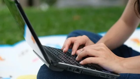 Asian woman work on notebook computer in the park Stock Footage 119695110