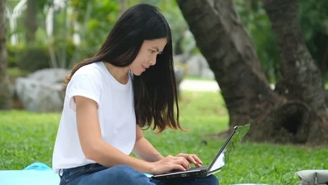 Asian woman work on notebook computer in the park Stock Footage 119695745