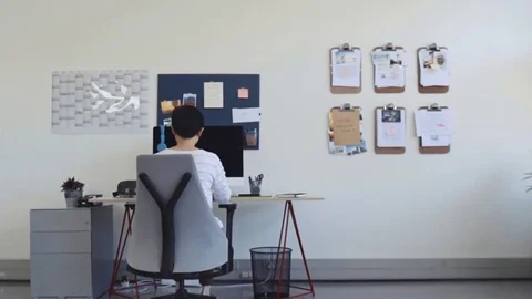 Asian woman working at computer in creative agency Stock Footage