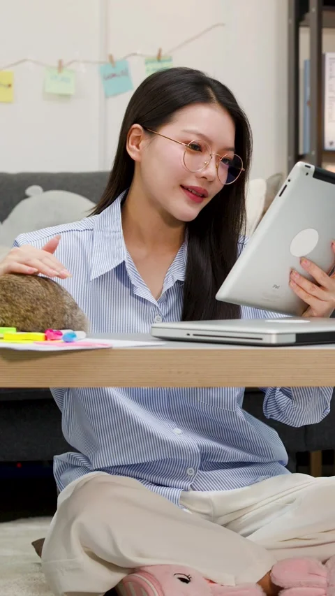 Asian Woman Working on Tablet While Petting Rabbit at Home Stock Footage 346800870