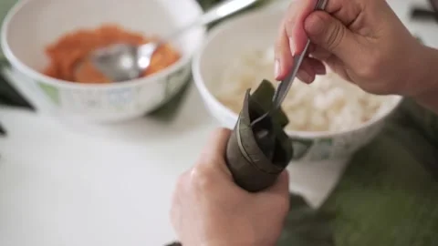 Asian woman wrap sticky or glutinous rice for cooking as Traditional Thai food Video stock 131132453