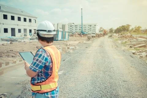 Asian women worker and engineer on building site using tablet for checking th Stock Photos