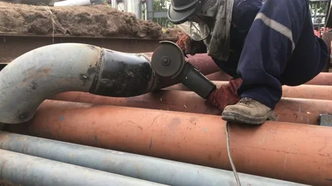 An Asian Worker Grinding or cutting welded pipe joint of mild steel pipe. Stock Footage 157284033