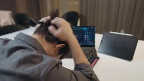 Asian worker man disappointed looking on trading charts, rug pull Stock Footage 169264694