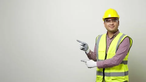 Asian worker in uniform hard hat safety glasses pointing the finger to blank spa Stock Footage 144260260