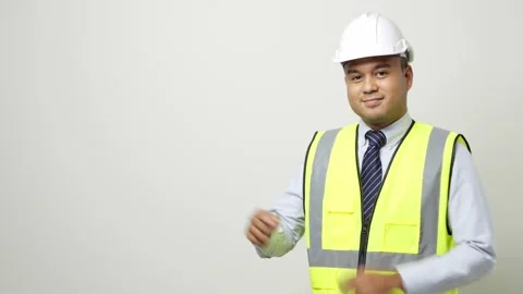 Asian worker in uniform hard hat pointing the finger to blank space for advertis Stock Footage 144261719