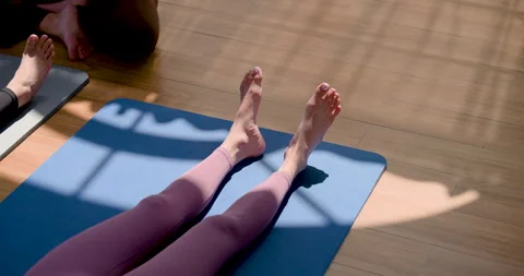 Asian yoga student performs slow motion foot flex and ankle mobility on mat Stock-Footage 341568256