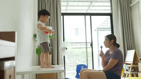 Asian young boy playing a small red toy guitar or ukulele Stock Footage 292863629