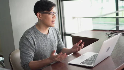 Asian young business man using laptop video conference talking to colleagues Stock Footage 136956798