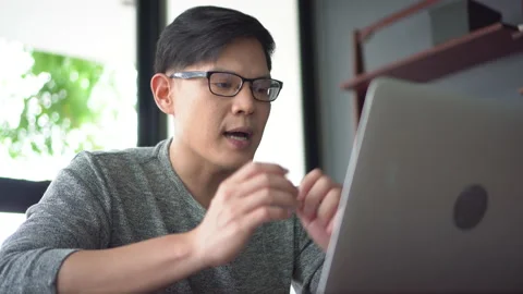 Asian young business man using laptop video conference talking to colleagues Stock Footage 158790177