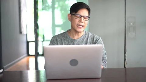 Asian young business man using laptop video conference talking to colleagues Stock Footage 158790323