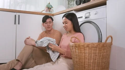 Asian young couple doing laundry together feeling tried , bored , arguing a.. Stock Footage 228784654