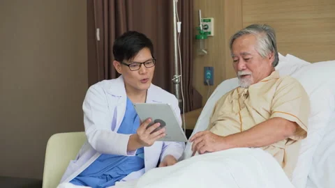 Asian young doctor using digital tablet explain the symptoms to the patient a Stock Footage 137163463
