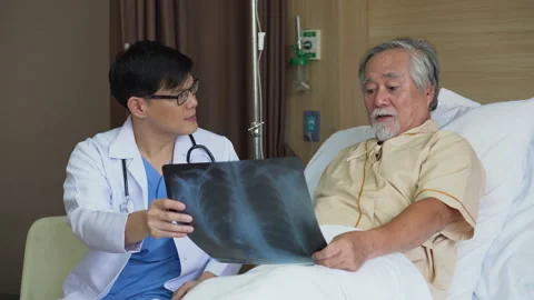 Asian young doctor using X-ray film explain the symptoms to the patient after Stock Footage 137163056