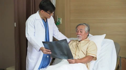 Asian young doctor using X-ray film explain the symptoms to the patient after Stock Footage 137165008
