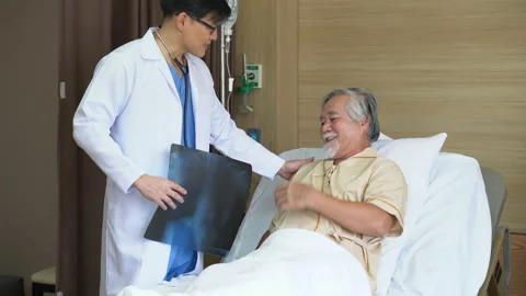 Asian young doctor using X-ray film explain the symptoms to the patient after Stock Footage 147733049
