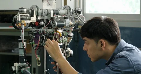 Asian young electronics engineer building, fixing robotics in laboratory. Video stock 94647413