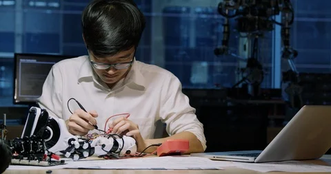 Asian young electronics engineer try to fix robot at lab. Stock Footage 111205117