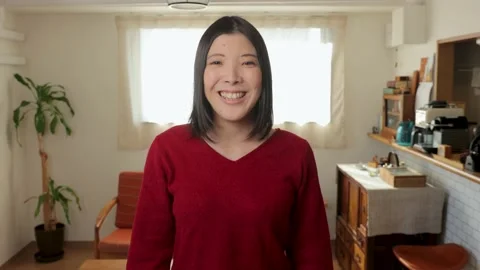 Asian young female smiles for the camera. Living room of apartment. 25P. Stock Footage 224908853