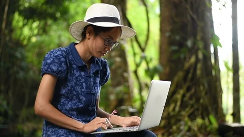 Asian young lady using computer laptop in park. Stock Footage 95704894