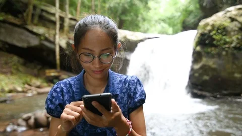 Asian young lady using smartphone in park. Stock Footage 95704763
