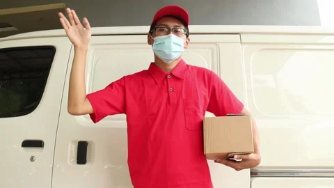 Asian young man delivery in red uniform with packages and great hands Stock Footage 141636627