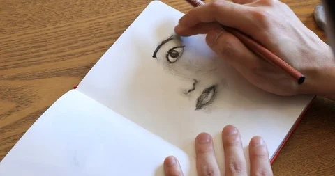 Asian young man drawing on notebook page with color pencils Stock Footage 90272064