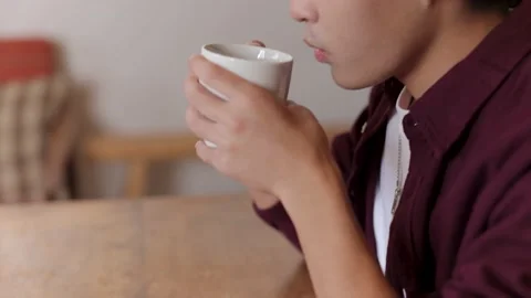 Asian young man drinks a cup of coffee and relax at home. Stock Footage 220760832