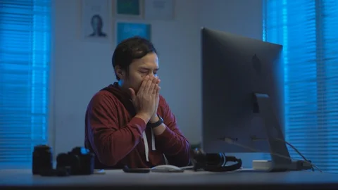  Asian young man getting tired and sleepy when working from home at night Video stock 129451877