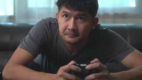 .Asian young man having fun playing video games sit sofa at home.Asian youn.. Stock Footage 246853580