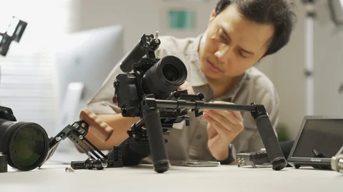 An Asian young man is installing a camera rig and fastening it Video stock 128407093