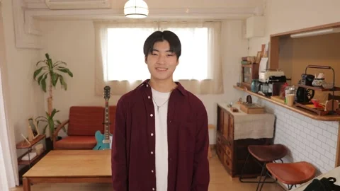 Asian young man smiles at the camera at his apartment. Stock Footage 220784171