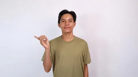 Asian young man smiling gesturing pointing to the side Stock Photos