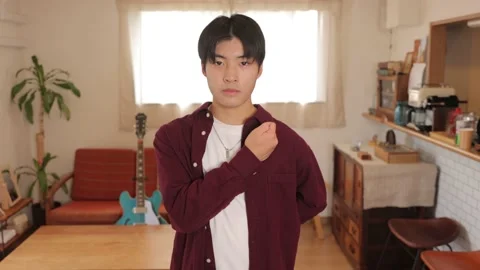Asian young man strikes a pose of animation. Dedicate your heart. Slow-mo Stock Footage 220794706