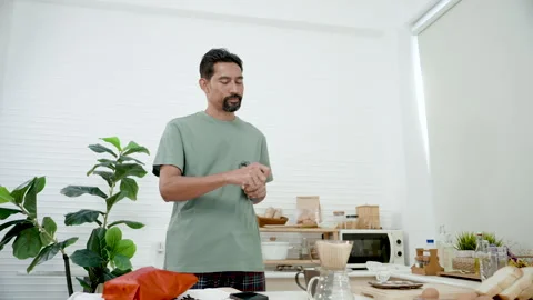 Asian young man using coffee grinder rotate coffee beans finely grind Stock Footage 241543859