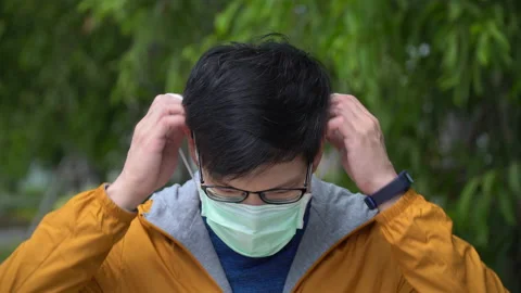 Asian young man wearing protective face mask during Coronavirus or Covid-19 p Stock Footage 146653250