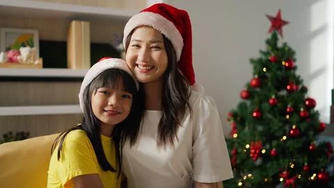 Asian young mother and daughter in santa hats smiling to camera. Merry Christmas Stock Photos