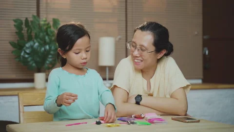 Asian young mother teach daughter to do homework and playing together Stock Footage