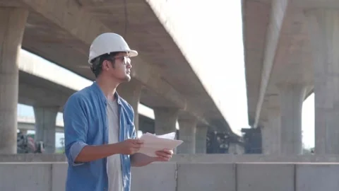 Asian young professional engineer worker in protective helmet and blueprint.. Video stock 244196293
