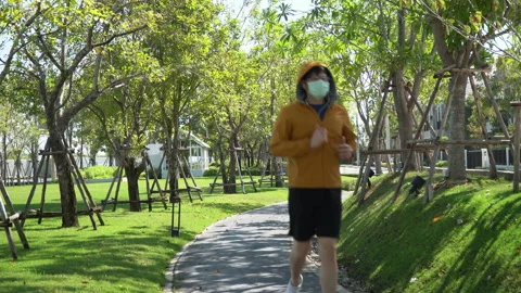Asian young runner man wearing sweater hood listening to music by earphones r Stock Footage 146652182